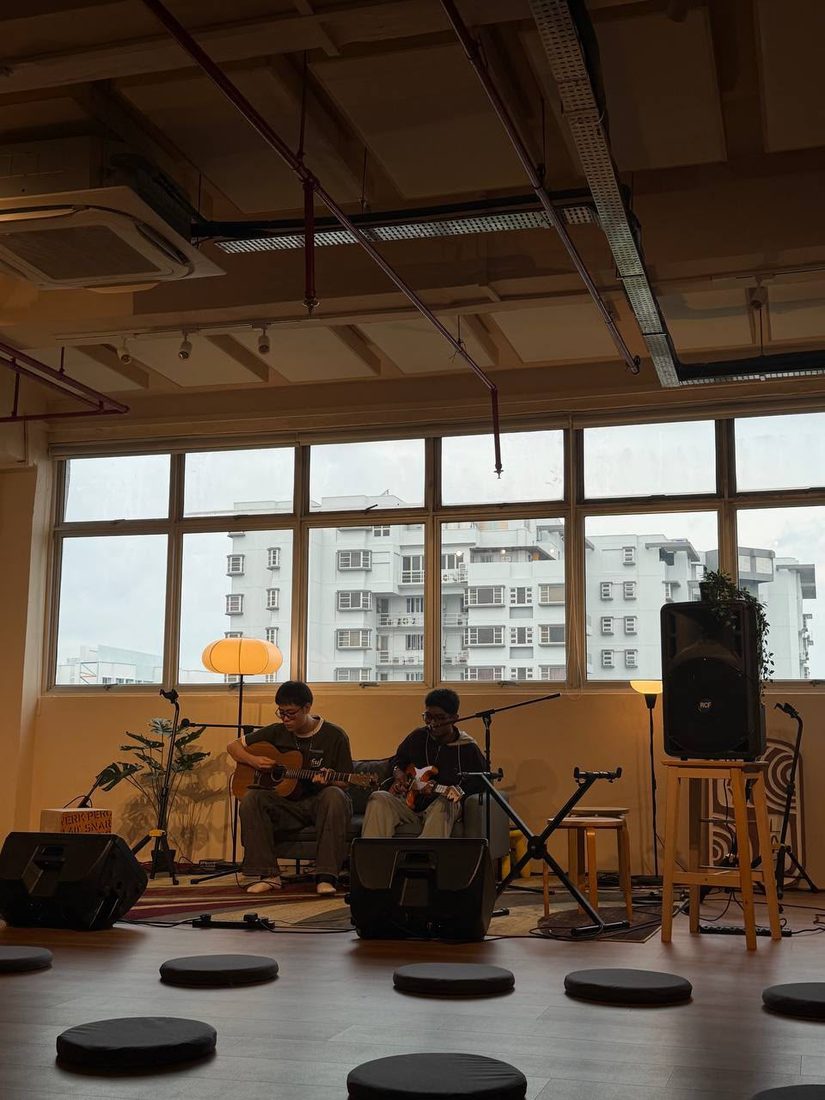 Jorell playing guitar alongside a friend at a live session
